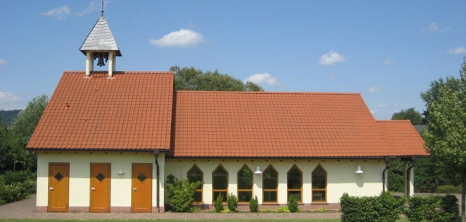 Seitliche Ansicht der Trauerhalle am neuen Friedhof im Ortsteil Altenhaßlau umgeben von Rasenflächen und Heckenbepflanzung