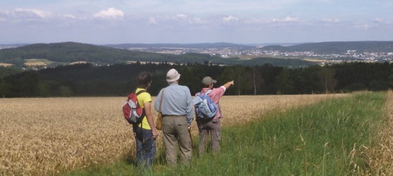 Wanderer blicken und weisen in Richtung Horizont