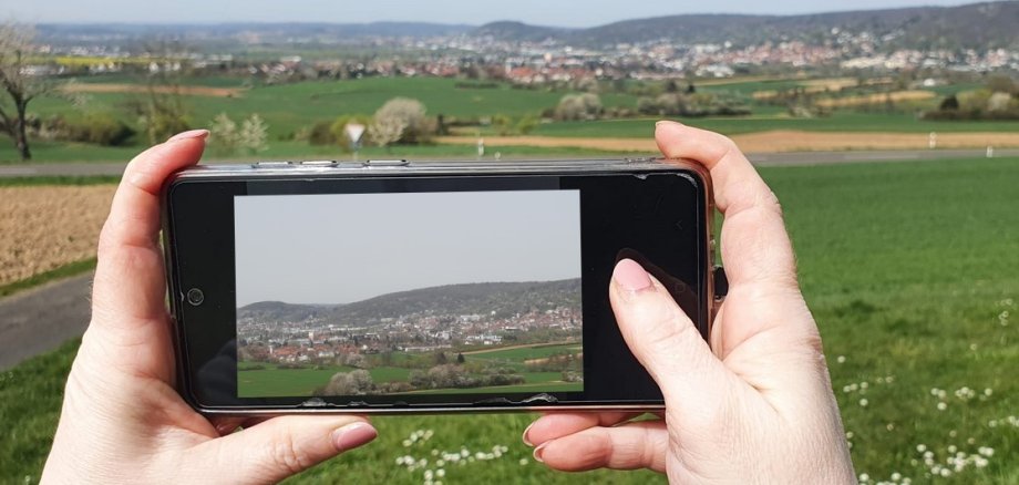 Mit der Kamerafunktion des Handys wird eine Landschaftsaufnahme getätigt